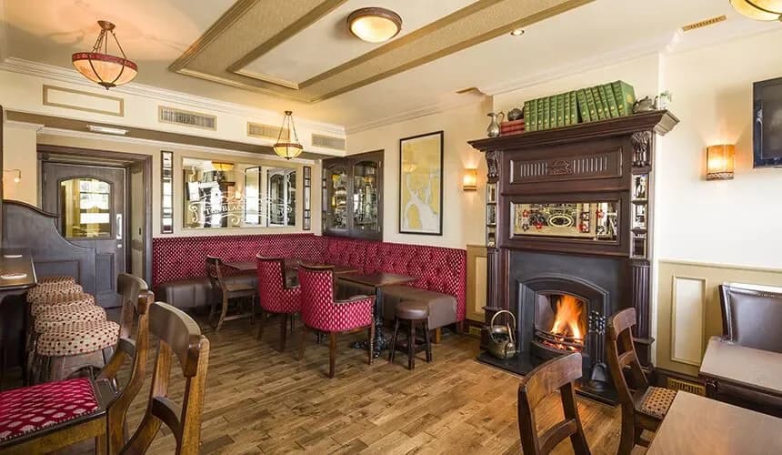 The fireplace, tables and seating inside The Black Sheep Pub
