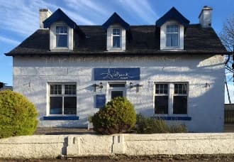 The white and blue frontage of Ashbank Hotel in Carradale