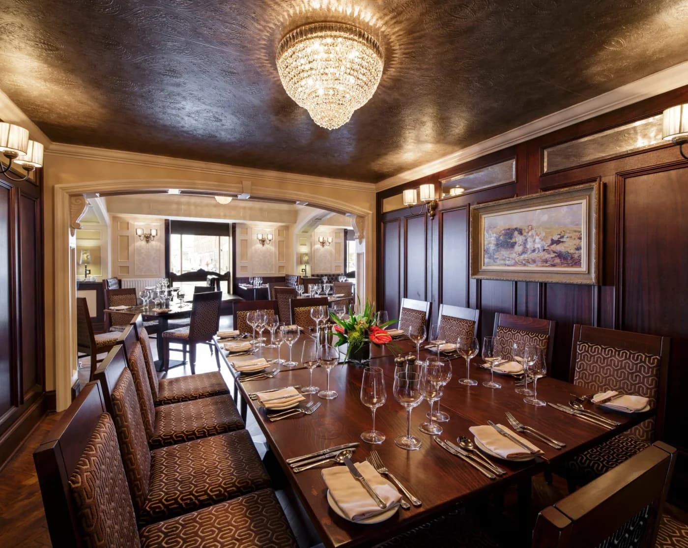 Tables set for dining beneath a chandelier at The Harbourview Grille