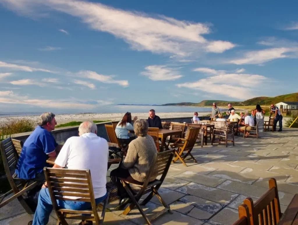Guests on the Argyll Hotel terrace beside Bellochantuy beach