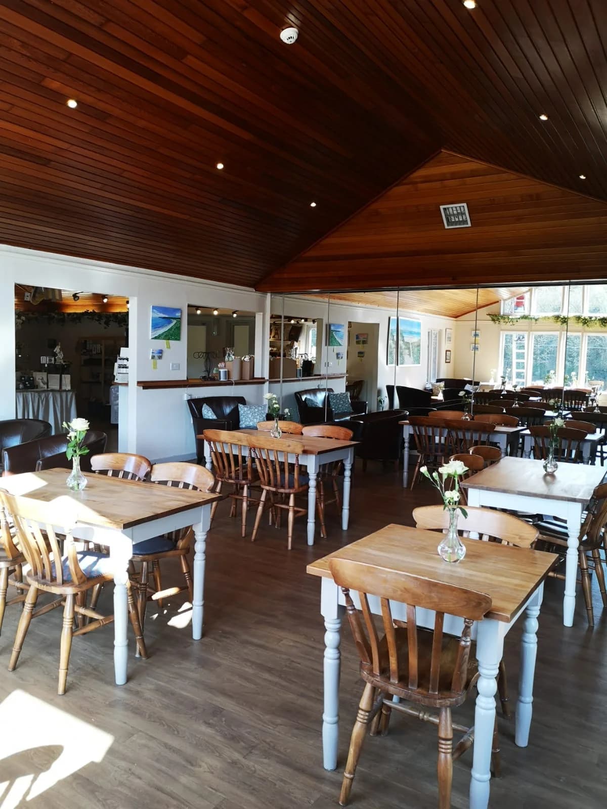 Wooden tables and chairs inside The Gather café