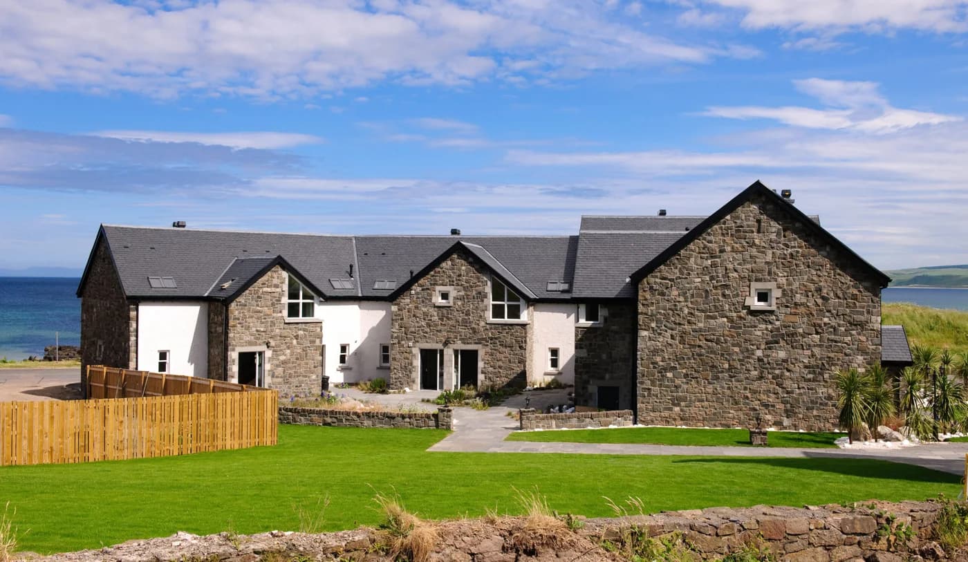 Stone-built Ugadale Cottages with lawn and Atlantic views